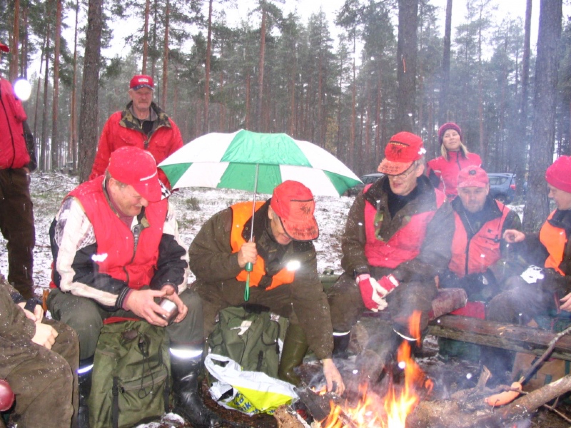 Seuran jäseniä talvinuotiolla perinteisellä metsästysretkellä